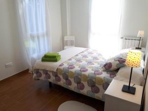 a bedroom with a bed and a table with a lamp at Apartamentos Somo 2 in Somo