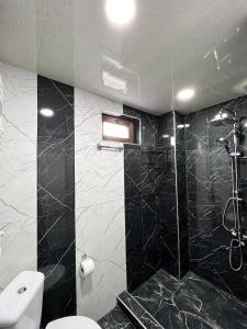 a black and white bathroom with a toilet and a shower at Royal Galaxy in Stepantsminda