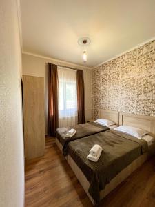 1 dormitorio con 2 camas y toallas. en Royal Galaxy, en Kazbegi