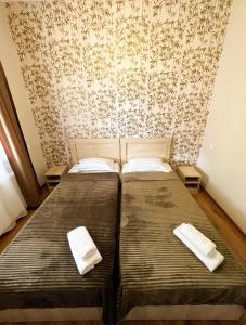 two beds in a small room with a wallpaper at Royal Galaxy in Kazbegi