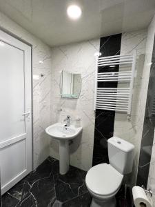 a bathroom with a white toilet and a sink at Royal Galaxy in Stepantsminda