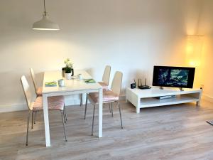 uma sala de jantar com mesa e cadeiras e uma televisão em Ferienwohnung Seestern em Sankt Peter-Ording