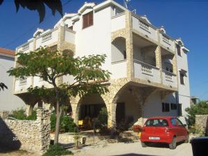 a red car parked in front of a building at Apartments Villa Estella in Srima
