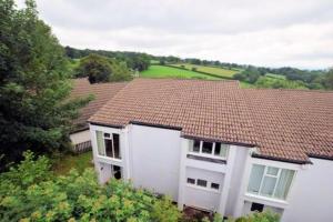 a white house with a red tile roof at Cornwall Countryside Lodges "Reserve Worldwide" Honicombe in Gunnislake