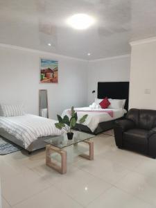 salon z 2 łóżkami i kanapą w obiekcie Sunrise Lodge w Kapsztadzie