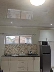 a kitchen with a sink and a refrigerator at Sunrise Lodge in Cape Town