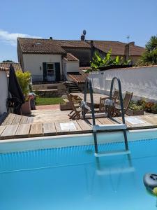a swimming pool with a wooden deck and a swimming pool at Gîte L'Ancienne Charcuterie in Buzet-sur-Baïse