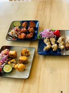 two plates of food on a table with food at Maddy's Kitchen and Accomodation in Gisenyi +6 photos