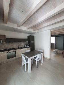 uma cozinha com mesa e cadeiras num quarto em CARLO'S Home em Catânia
