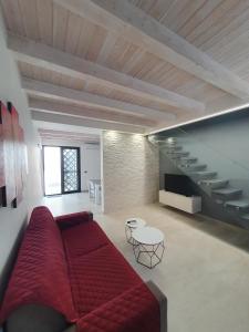 a living room with a red couch and a staircase at CARLO'S Home in Catania