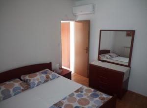 a bedroom with a bed and a mirror at Dragica 2 in Palit