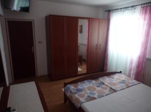 a bedroom with a bed and a closet and a window at Dragica 2 in Palit