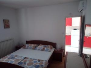 a bedroom with a bed and a door to a kitchen at Dragica 2 in Palit