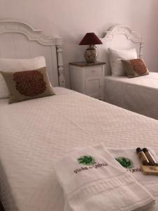 a bedroom with two beds with towels on them at Vinha da Quinta in Sintra