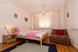 a bedroom with a bed and a chair at Bogdanoski Studios & Guest Rooms in Ohrid