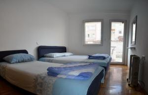 two beds in a room with two windows at City Center Apartments Ohrid in Ohrid