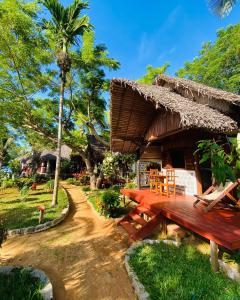 Ampangorinana的住宿－Tamarin Lodge，配有木桌和长凳的度假酒店