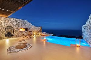 a villa with a swimming pool at night at Emerald Villas & Suites - The Finest Hotels Of The World in Agios Nikolaos