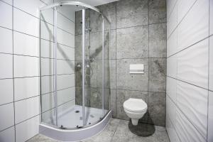 a bathroom with a shower and a toilet at Apart Bałtyk Pokoje & Apartamenty in Łeba