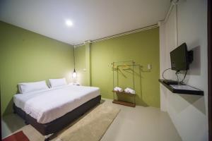 湄林First Residence的卧室里有一张白色的床和一台电视