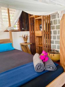a bedroom with a bed with towels and flowers at Tamarin Lodge in Ampangorinana