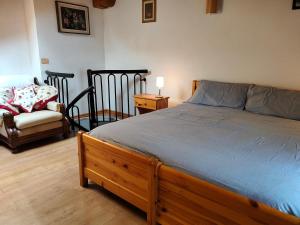 una camera con letto in legno e sedia di Appartamento Chatrian 2 CIR-TORGNON-0019 a Torgnon