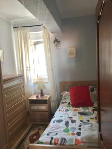 a small bedroom with a bed and a window at La casina del Reloj con vistas al mar in Lastres