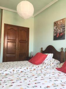 a bedroom with a bed with red pillows on it at La casina del Reloj con vistas al mar in Lastres