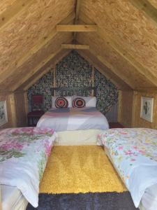 a bedroom with two beds in a attic at Shannon Estuary Glamping Budget-Sustainable-Biodiversity Habitat--Rustic-Countryside Holiday Accommodation in Effernan