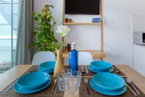 a dining room table with blue plates and a blue bottle at Modern Apt with Pool - Yumbo & Beach in Maspalomas
