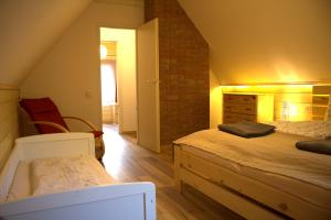 a attic bedroom with a bed and a brick wall at Lili's Lovely Log Home in the Forest in Bükkszentkereszt