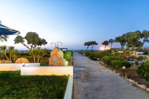 a walkway leading to a garden with a building at Hotel Tsagarakis Beach in Amoudara Herakliou