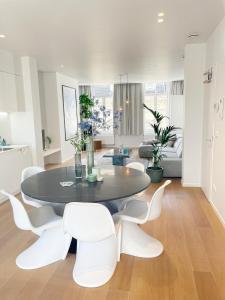 ein Esszimmer mit einem Tisch und weißen Stühlen in der Unterkunft Jacob’s Getaway in Gent