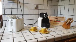 a kitchen counter with two cups and a toaster at Appartamento Vacanze a Manciano in Manciano