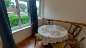 a table and chairs in a room with a window at Jungas nams in Liepāja