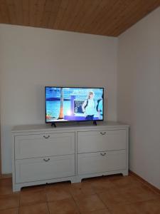 a flat screen tv sitting on top of a dresser at Ferienwohnung Aichelberg in Aichelberg