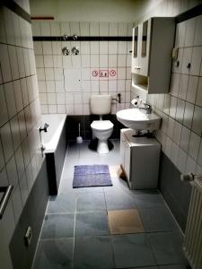 a bathroom with a sink and a toilet and a tub at Ferienwohnung Axel - nahe Chemnitz in Limbach - Oberfrohna