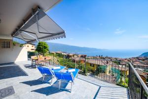 a patio with blue chairs and a table on a balcony at Regina in Tignale