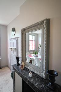 um espelho sentado numa mesa num quarto em Le Grand Presbytère de Beaulieu em Beaulieu-lès-Loches