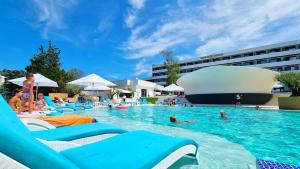 una piscina con sillas y gente en el agua en Grand Hotel Caraiman, en Neptun