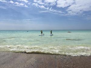 two people are standing on paddle boards in the ocean at The Studio in Worthing