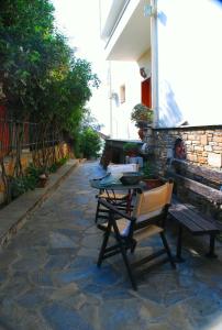 a patio with a table and chairs on a stone path at Studios Efi in Kala Nera