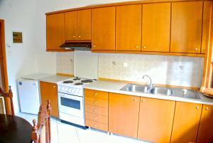 a kitchen with wooden cabinets and a sink at Studios Efi in Kala Nera