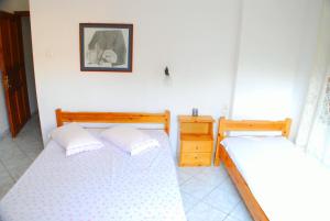 two twin beds in a room with a picture on the wall at Studios Efi in Kala Nera