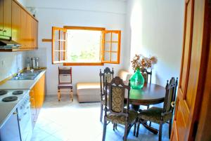 a kitchen with a table and chairs in a kitchen at Studios Efi in Kala Nera