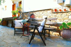 a table and chairs sitting next to a stone wall at Studios Efi in Kala Nera
