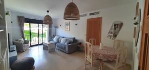 uma sala de estar com um sofá e uma mesa em Apartamento con jardín y piscina em Marbella