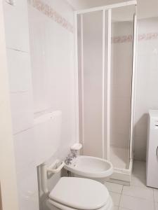 ein weißes Bad mit einem WC und einem Waschbecken in der Unterkunft Fulvia's cozy apartment with terrace in Monterosso al Mare