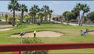 a group of people playing golf on a golf course at Taylors Camposol Apartment in Mazarrón