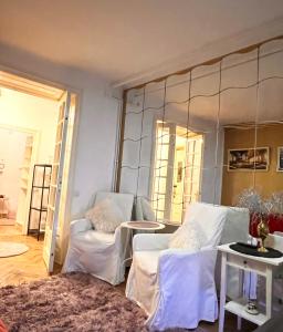 a living room with two white chairs and a mirror at Art Deco Mosilor in Bucharest